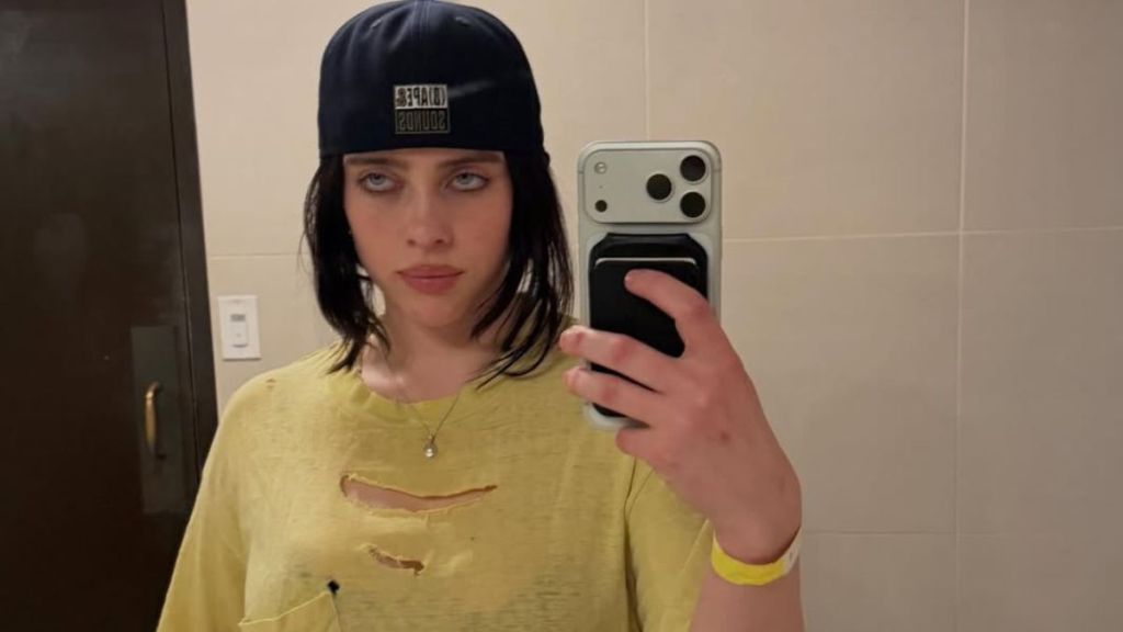 Billie Eilish Drinks From Milk Bottle Wearing a Bold Top