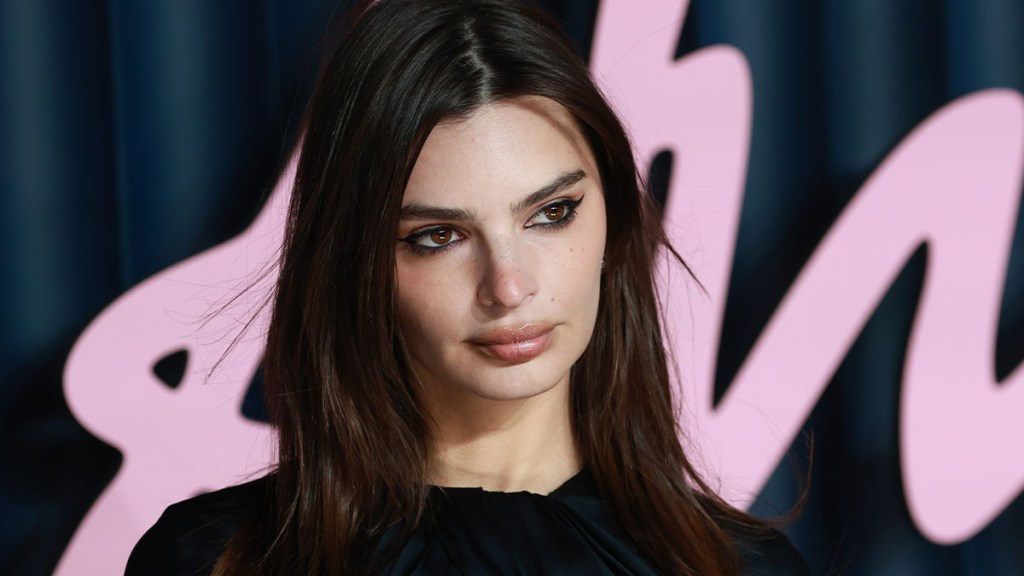 Emily Ratajkowski Strikes a Racy Pose on a Mysterious Flight