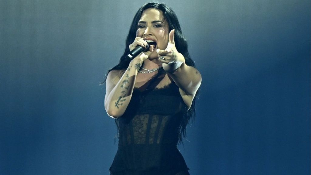 Demi Lovato Reveals Tour Dates in Fully Sheer Bodysuit & Fishnet Tights