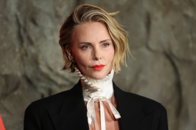 Charlize Theron Goes Topless Under Men’s Jacket for Apex Premiere